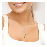 Une femme en haut blanc sourit, mettant en valeur le Perlinea Collier TOI & MOI | Perles de Culture Vertes Tonic, un délicat collier en argent 925 avec deux pendentifs en perles vertes, montré à partir des épaules.