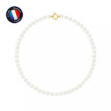 Le Collier NOELYSE de Perlinea est composé de perles blanches rondes de 7/8 mm avec un fermoir en or, disposées en cercle sur un fond blanc. Une étiquette "Made in France" en haut à gauche met en valeur cette pièce raffinée.