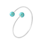 Le bracelet Perlinea Jonc KATALÏA présente un design minimaliste en argent 925, rehaussé de perles rondes en turquoise bleu à chaque extrémité.