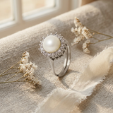 Bague argent 925 ornée d'une perle de culture blanche entourée de zircons.