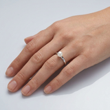 Bague jonc argent 925 ornée d'une perle de culture blanche portée à l'index.