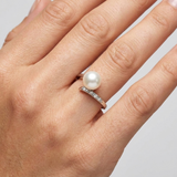 Bague or blanc 9 carats avec perle de culture blanche et diamants portée à l'annulaire.