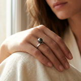 Bague or blanc 9 carats et perle de culture noire de Tahiti portée à la main.