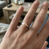 Bague en or blanc 9 carats portée à l'annulaire, ornée d'une perle de culture rose 8/9mm.