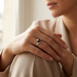 Bague en or blanc 9 carats sertie d'une perle de Tahiti noire, portée à l'annulaire.