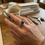 Bague or blanc 9 carats portée à la main, ornée d'une perle de culture noire de Tahiti.