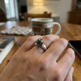 Bague or blanc 9 carats portée à l'annulaire, ornée d'une perle de Tahiti gris-vert.