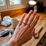 Bague en or jaune 9 carats ornée d'une perle de culture dorée, portée à l'annulaire.