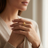 Bague en or jaune 9 carats ornée d'une perle de culture dorée, portée à la main.