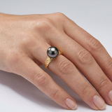 Bague en or jaune 9 carats ornée d'une perle de Tahiti grise portée à l'index.