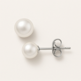 Une paire de boucles d'oreilles Perlinea Boucle d'Oreilles Bouton AYA avec des perles de culture d'eau douce blanches de 7/8 mm et des montants en argent, vues de dessus et de côté sur un fond blanc.
