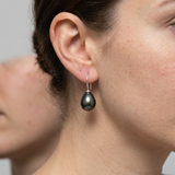 Boucles d'oreilles en argent 925 avec perle de Tahiti noire portées à l'oreille.