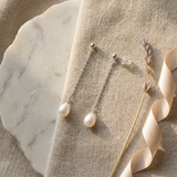 Boucles d'oreilles pendantes en or blanc 9 carats avec chaîne fine et perles blanches ovales.