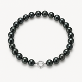 Bracelet en argent 925 avec perles noires sur fond neutre, fermoir anneau argenté.