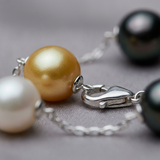 Gros plan sur le fermoir argent 925 d'un bracelet perles de Tahiti et eau douce blanc et or.