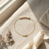 Bracelet chaîne or jaune 9 carats avec rangée de perles blanches et fermoir anneau.