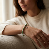 Bracelet en perles d'eau douce vertes et argent 925 avec charm étoile, porté au poignet.