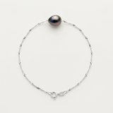Bracelet or blanc 9 carats avec perle noire aux reflets irisés sur chaîne torsadée et fermoir anneau.