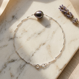 Bracelet or blanc 9 carats avec perle de Tahiti baroque, chaîne torsadée et fermoir anneau.