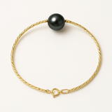 Bracelet en or jaune 9 carats torsadé avec une perle de culture noire de Tahiti, fermoir anneau.