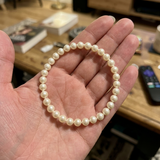 Bracelet perles d'eau douce blanches en argent 925 présenté à plat dans une paume de main.