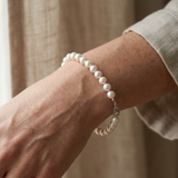 Bracelet perles d'eau douce blanches en argent 925 porté au poignet.