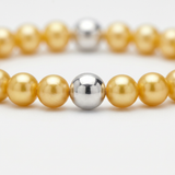 Gros plan sur bracelet perles d'eau douce dorées et bille argent 925 intercalée.