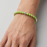 Bracelet en perles d'eau douce vertes et argent 925 porté au poignet.