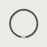 Bracelet perles noires 4/5 mm sur fil avec fermoir anneau argent 925, fond neutre.