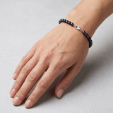 Bracelet perles noires 5/6 mm argent 925 avec fermoir mousqueton porté au poignet.