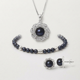 Parure collier, bracelet et boucles d'oreilles avec perles noires et montures serties.