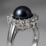 Bague argent 925 avec perle noire entourée de diamants, vue en gros plan sur le sertissage.