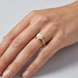 Bague spirale en or jaune 9 carats ornée d'une perle de culture blanche, portée à l'index.