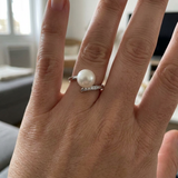 Bague or blanc 9 carats avec perle de culture blanche et diamants, portée à l'index.