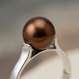 Gros plan sur la perle de culture chocolat ronde sertie sur bague en or blanc 9 carats.