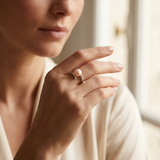Bague en or blanc 9 carats ornée d'une perle de culture rose, portée à l'annulaire.