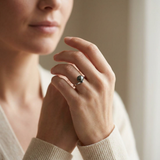 Bague en or blanc 9 carats sertie d'une perle de Tahiti noire, portée à l'index.