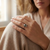 Bague or blanc 9 carats et perle de Tahiti noire portée à l'annulaire, avec pavage de diamants.