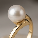 Gros plan sur une bague en or jaune 9 carats sertie d'une perle de culture blanche ronde.