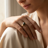 Bague en or jaune 9 carats ornée d'une perle de Tahiti noire, portée à l'index.