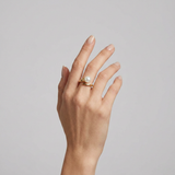 Bague en or jaune 9 carats sertie d'une perle de culture blanche, portée à la main.