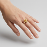Bague or jaune 9 carats et perle de culture dorée portée à l'index d'une main.