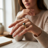Bague or jaune 9 carats sertie d'une perle de Tahiti noire portée à l'annulaire.