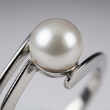 Gros plan sur la perle de culture blanche sertie en or blanc 9 carats de la bague Zigzag.