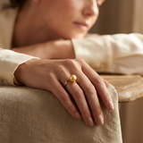 Bague zigzag en or jaune 9 carats ornée d'une perle de culture dorée, portée à l'index.