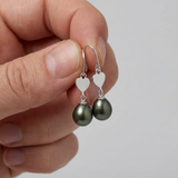 Boucles d'oreilles argent 925 coeur avec perles noires, tenues en main.
