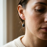 Boucles d'oreilles or jaune 9 carats portées, avec perle de culture poire noire de Tahiti.