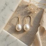 Boucles d'oreilles pendantes en or jaune 9 carats avec perles de culture blanches ovales.