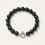 Bracelet argent 925 et perles noires 7/8 mm avec fermoir anneau sur fond neutre.