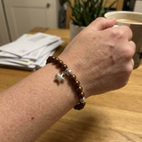 Bracelet en perles d'eau douce chocolat argent 925 avec charm étoile, porté au poignet.